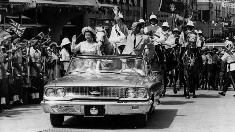 February 18, 1966: The Queen and Prince Philip drive through Barbados waving to crowds.  (Photo by Keystone / Getty Images)