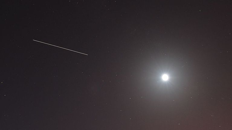 This long exposure image shows the International Space Station streaming across the sky through the moon prior to the launch of the Space Shuttle Discovery on April 5, 2010 at the Kennedy Space Center in Florida.  Discovery will carry a multi-purpose logistics unit filled with science lab racks on board the International Space Station.  AFP PHOTO / Stan HONDA (Image credit STAN HONDA / AFP must be read via Getty Images)