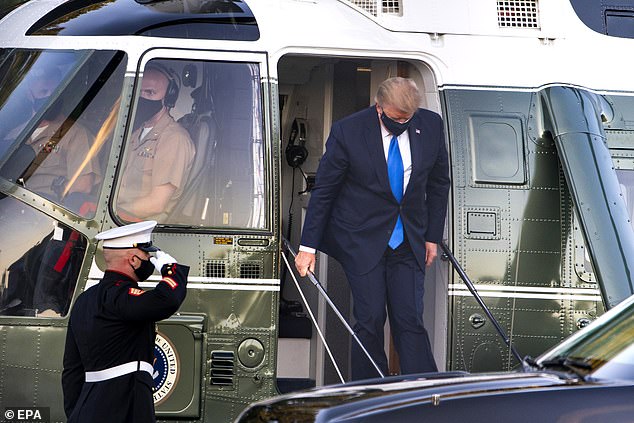 Pictured is Trump leaving the helicopter upon arrival at the hospital on Friday night