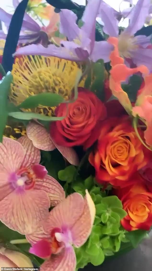 Gorgeous: Pop blonde can also be seen happily greeting her friend Lizzie who introduced her to a flower arrangement from Interscope Records