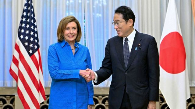 Fumio Kishida (right) and Pelosi (left) shake hands in front of reporters (5/8/2022).