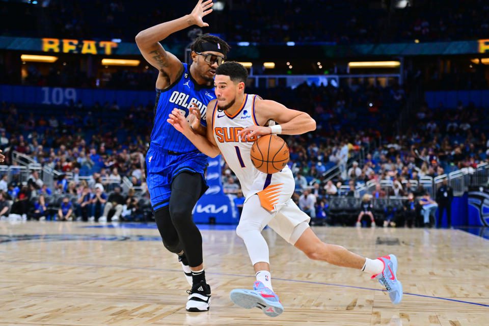 ORLANDO, FL - NOVEMBER 11: Devin Booker #1 of the Phoenix Suns leads the basket against Wendell Carter Jr.  #34 for the Orlando Magic in the second half of a game at Amway Center on November 11, 2022 in Orlando, Florida.  Note to User: User expressly acknowledges and agrees, by downloading or using this image, that User agrees to the terms and conditions of the Getty Images License Agreement.  (Photo by Julio Aguilar/Getty Images)