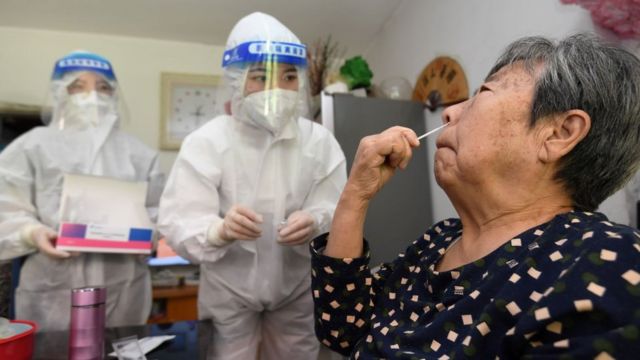 A staff member instructs elderly people on an antigen test at their home in Guiyang, Guizhou Province, China, September 7, 2022.